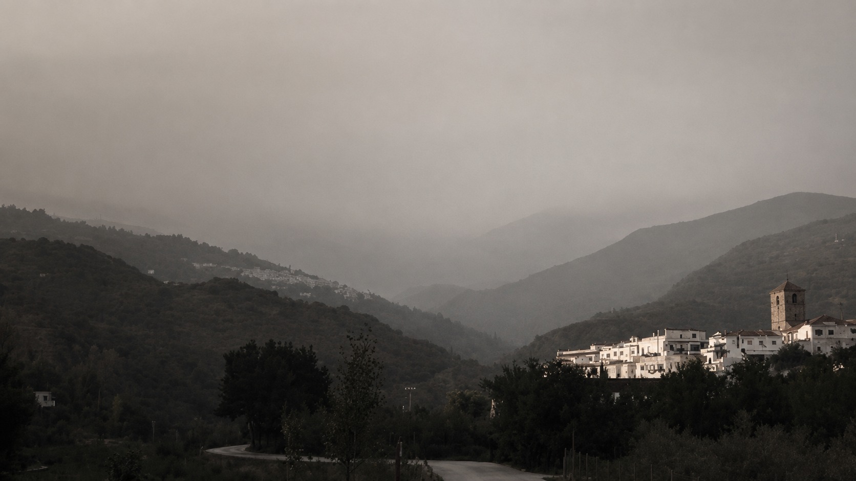 A misty mountain village in subdued morning light